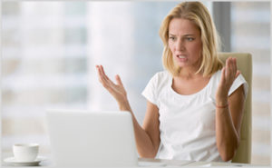 Woman looking frustrated at computer screen